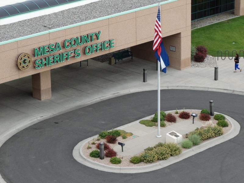 Aerial photograph ofthe outside of the Mesa County Sheriff's Office building showing a round-about driveway and flag pole with U.S. and State of Colorado flags.